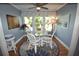 Charming dining room with glass table and white wicker chairs at 940 Virginia St # 208, Dunedin, FL 34698