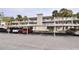 Two-story condo building with covered parking and lush landscaping at 940 Virginia St # 208, Dunedin, FL 34698