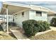 Light blue mobile home with carport and landscaped yard at 9790 66Th N St # 33, Pinellas Park, FL 33782