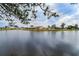 Peaceful lakefront view of homes with lush landscaping at 1015 El Rancho Dr, Sun City Center, FL 33573