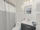 Bathroom with black vanity, white tiled walls, and striped shower curtain at 10603 Coquita Ln, Tampa, FL 33618