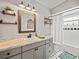 Bathroom with gray vanity, wood framed mirror, and patterned floor at 10603 Coquita Ln, Tampa, FL 33618
