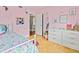 Pink bedroom with white dresser, and floral bedding at 10603 Coquita Ln, Tampa, FL 33618