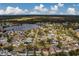 Wide aerial view showcasing the house's location in a residential neighborhood and nearby lake at 11607 Branch Mooring Dr, Tampa, FL 33635