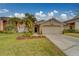 Tan house with a two-car garage and palm trees in the front yard at 11607 Branch Mooring Dr, Tampa, FL 33635