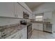 Modern kitchen with white cabinets, granite counters, and stainless steel appliances at 11607 Branch Mooring Dr, Tampa, FL 33635