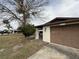 Ranch-style house with brown garage door and mature tree in front at 12812 1St Isle, Hudson, FL 34667