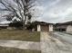 Ranch-style house with brown garage door and mature tree in front at 12812 1St Isle, Hudson, FL 34667