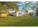 Spacious backyard with grassy lawn, wooden fence, and a glimpse of a pool at 12918 Cambridge Ave, Tampa, FL 33624