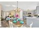 Modern dining area with a chandelier and view into the living room and kitchen at 12918 Cambridge Ave, Tampa, FL 33624