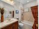 Bathroom with tub, wood vanity, and decorative curtain at 13315 Carnoustie Cir, Dade City, FL 33525