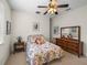 Bedroom with floral bedding, ceiling fan and dresser at 13315 Carnoustie Cir, Dade City, FL 33525