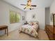 Bedroom with floral bedding, ceiling fan, and wood furniture at 13315 Carnoustie Cir, Dade City, FL 33525