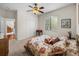 Bedroom with floral bedding, ceiling fan and access to another room at 13315 Carnoustie Cir, Dade City, FL 33525