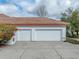 Two-car garage with white doors and concrete driveway at 13315 Carnoustie Cir, Dade City, FL 33525
