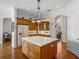 Kitchen features wood cabinets, a large island, and views to the Gathering room at 13315 Carnoustie Cir, Dade City, FL 33525