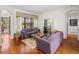 Spacious living room with hardwood floors, two purple sofas, and a view of the pool at 13315 Carnoustie Cir, Dade City, FL 33525