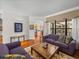 Open living area with hardwood floors, two purple sofas, and view of Gathering room and pool at 13315 Carnoustie Cir, Dade City, FL 33525