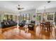 Spacious living room with hardwood floors, leather furniture, and pool view at 13315 Carnoustie Cir, Dade City, FL 33525