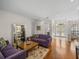 Bright living room featuring hardwood floors, two sofas, and access to the front entry at 13315 Carnoustie Cir, Dade City, FL 33525