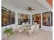Covered patio with seating area, ceiling fan, and views of the pool at 13315 Carnoustie Cir, Dade City, FL 33525