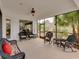 Cozy screened porch with wicker furniture and ceiling fan at 13315 Carnoustie Cir, Dade City, FL 33525
