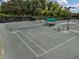 Well-maintained tennis courts with a shaded seating area at 13315 Carnoustie Cir, Dade City, FL 33525