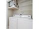 White washer and dryer in well-lit laundry room with overhead shelving at 1429 Villa Capri Cir # 306, Odessa, FL 33556