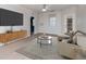 Living room with wood-like floors, staged furniture, and large TV at 1429 Villa Capri Cir # 306, Odessa, FL 33556