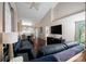 Open living area with dark leather couches, hardwood floors, and a large TV at 158 Sun Isle Cir, Treasure Island, FL 33706