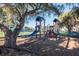 Community playground with playset, shaded by a large tree at 158 Sun Isle Cir, Treasure Island, FL 33706