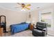 Cozy bedroom with wood-look floors, ceiling fan, and a comfortable recliner at 16346 Ashington Park Dr, Tampa, FL 33647