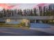 Tan house with gray roof, carport, and landscaping at dusk at 1752 Atrium Dr, Sun City Center, FL 33573