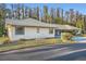 Light beige house with gray roof, small patio furniture, and carport at 1752 Atrium Dr, Sun City Center, FL 33573