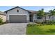 Modern house with gray siding, a two-car garage, and a well-maintained lawn at 2009 Gardenia Ave, Port Charlotte, FL 33953