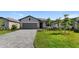 Two-story house with gray siding, paved driveway, and landscaped lawn at 2009 Gardenia Ave, Port Charlotte, FL 33953