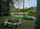 Stone fire pit with a grassy area and swamp view at 21732 Bell Lake Rd, Land O Lakes, FL 34639