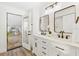 Modern bathroom with double vanity, marble countertop, and a view of dining area at 2181 Wateroak N Dr, Clearwater, FL 33764