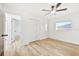 Spacious bedroom featuring wood-look floors, double doors, and a ceiling fan at 2181 Wateroak N Dr, Clearwater, FL 33764