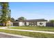 Ranch style home with gray roof and a beautifully landscaped yard at 2181 Wateroak N Dr, Clearwater, FL 33764