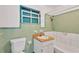 Small bathroom with light green tiled walls and a tub at 2303 E Osborne Ave, Tampa, FL 33610