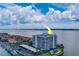 Aerial view of waterfront condo building with pool and tennis courts at 240 Sand Key Estates Dr # 213, Clearwater, FL 33767