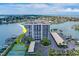 Aerial view of waterfront condo building with tennis courts and parking at 240 Sand Key Estates Dr # 213, Clearwater, FL 33767