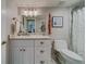 Bathroom with white vanity, marble tile, and shower at 240 Sand Key Estates Dr # 213, Clearwater, FL 33767