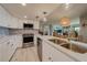 Bright kitchen boasts stainless steel appliances, white cabinetry, and a large island at 240 Sand Key Estates Dr # 213, Clearwater, FL 33767