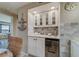 White wet bar with marble backsplash and wine cooler at 240 Sand Key Estates Dr # 213, Clearwater, FL 33767