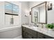 Bathroom featuring a marble countertop, wood cabinets and a modern mirror at 2502 S Dundee St, Tampa, FL 33629