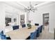 An open dining room with views of the living room, wine cellar and a modern chandelier at 2502 S Dundee St, Tampa, FL 33629