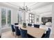 Dining room featuring modern chandelier lighting, plantation shutters and views into the living room at 2502 S Dundee St, Tampa, FL 33629