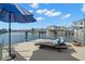 Waterfront dock with cushioned chaise lounge, blue umbrella, and beautiful views at 2502 S Dundee St, Tampa, FL 33629
